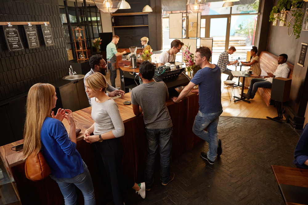 People waiting at a coffee shop counter for their orders